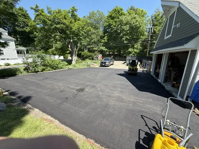 New asphalt driveway leading to a two-car garage at a Massachusetts home