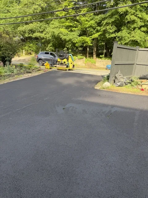 All Starr Paving roller compacting fresh black asphalt on a residential driveway