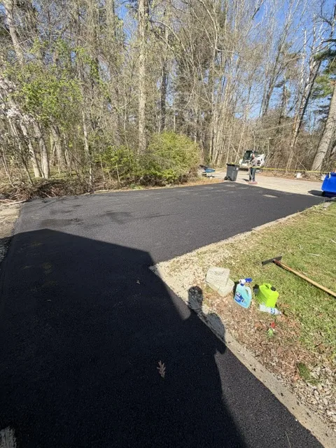 Wide new asphalt pad and turnaround on a wooded Massachusetts lot